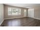 Bright living room featuring wood flooring, neutral paint, a large window, and a coat closet near the front door at 2041 W Flat Shoals Ter, Decatur, GA 30034