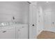 Bright laundry room features a modern washer and dryer with white wire shelving at 3475 Oak Valley Rd # 660, Atlanta, GA 30326