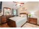 Bedroom with neutral walls, hardwood floors, ceiling fan, dresser with mirror, and a bed with a patterned comforter at 624 Spanish Oak Dr, Acworth, GA 30102