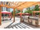 Community grilling area with a stainless steel grill, picnic tables and red shaded cabanas in a landscaped setting at 799 Hammond Dr # 321, Atlanta, GA 30328