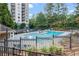 Relaxing community pool with lounge seating, landscaping and trees with high-rise apartment homes in the background at 799 Hammond Dr # 321, Atlanta, GA 30328