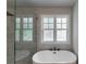 Bright bathroom featuring a soaking tub and a shower with rainfall shower head and marble tile at 842 Bridgewater Sw St, Atlanta, GA 30310