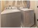 Efficient laundry room featuring a washer, dryer, and convenient ironing board storage at 842 Bridgewater Sw St, Atlanta, GA 30310