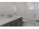 Stylish bathroom with tiled bathtub, white vanity, and ample lighting at 2023 Fern Mountain Ln, Marietta, GA 30064