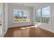 Bright living room featuring hardwood floors and large windows with a view of the outdoor deck and wooded area at 2023 Fern Mountain Ln, Marietta, GA 30064