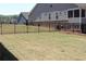 This spacious backyard features a well-manicured lawn, an iron fence, and the back of the home at 2925 Coach River Way, Cumming, GA 30040