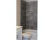 A tiled shower-tub features a shower head, faucet and a toilet in front of the tub at 2925 Coach River Way, Cumming, GA 30040