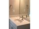 A bathroom vanity with a white countertop, silver fixtures, and a mirror surrounded by two towel rings at 2925 Coach River Way, Cumming, GA 30040