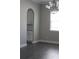 Open dining room with modern chandelier, gray flooring and arched doorway to kitchen at 2925 Coach River Way, Cumming, GA 30040