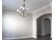 Elegant dining area with crown molding, an arched doorway, and a stylish chandelier at 2925 Coach River Way, Cumming, GA 30040