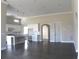 Open concept living space with hardwood floors, a kitchen view, and arched doorway at 2925 Coach River Way, Cumming, GA 30040