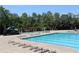 A large community pool with a slide is surrounded by lounge chairs and greenery at 2925 Coach River Way, Cumming, GA 30040