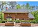 View of backyard featuring a brick house, manicured lawn, trees, and raised garden beds with a pea gravel walkway at 297 Breeze Hill Ln, Canton, GA 30114