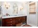 Bright bathroom with a dark wood vanity, marble countertop, and sconce lighting at 297 Breeze Hill Ln, Canton, GA 30114