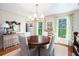 Formal dining room with a round wood table, chandelier, and bright floral curtains at 297 Breeze Hill Ln, Canton, GA 30114