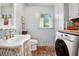 Charming laundry room features brick flooring, a washer, and a window for natural light at 297 Breeze Hill Ln, Canton, GA 30114