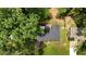 Aerial view of a home featuring a dark roof, backyard greenery, and surrounding trees at 3925 Chicamauga Ne Dr, Kennesaw, GA 30144