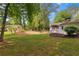 Expansive backyard featuring lush green lawn and a shed, surrounded by mature trees, perfect for outdoor enjoyment at 3925 Chicamauga Ne Dr, Kennesaw, GA 30144
