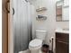 Small bathroom with wood-look floors, a toilet, vanity, mirror and storage shelves at 3925 Chicamauga Ne Dr, Kennesaw, GA 30144