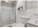 All-white bathroom with glass shower, white hexagon tile floor, and wall-mounted storage at 3925 Chicamauga Ne Dr, Kennesaw, GA 30144