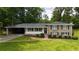 Traditional home with a neatly landscaped front yard and attached carport at 3925 Chicamauga Ne Dr, Kennesaw, GA 30144