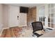 Office space featuring a brick wall accent, french doors, wood floor, and colorful area rug at 3925 Chicamauga Ne Dr, Kennesaw, GA 30144