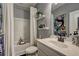 Cozy bathroom featuring a tub with shower, decorative shelves, and a stylish vanity with sink and fixtures at 1014 Starmoss Ln, Conyers, GA 30094
