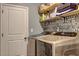Functional laundry room with modern washer and dryer, open shelving, and unique typography wallpaper at 1014 Starmoss Ln, Conyers, GA 30094