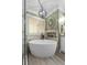 Stylish bathroom highlighting a modern tub with elegant fixtures, complemented by sophisticated tiling and lighting at 125 Abner Dr, Mcdonough, GA 30252