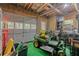 Cluttered garage with green riding lawnmower and an overhead door at 125 Abner Dr, Mcdonough, GA 30252