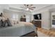 Comfortable main bedroom featuring a tray ceiling, a ceiling fan, hardwood floors, and abundant natural light at 125 Abner Dr, Mcdonough, GA 30252