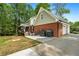 Back of house with brick base and vinyl siding featuring a screened porch, grill, and garage doors at 125 Abner Dr, Mcdonough, GA 30252