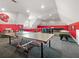 Open concept game room with ping pong table, pool table, bar seating and black leather couches at 2220 Peachtree Rd, Cumming, GA 30041