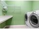 Laundry room with modern washer and dryer, folding table and wire shelving at 2220 Peachtree Rd, Cumming, GA 30041