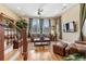 Inviting living room featuring hardwood floors, a ceiling fan, and large windows for natural light at 2220 Peachtree Rd, Cumming, GA 30041
