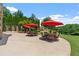 Outdoor patio with stone border and seating areas with red umbrellas at 2220 Peachtree Rd, Cumming, GA 30041