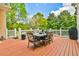Large back deck with a table and chairs overlooking a green, wooded backyard at 3233 Bagley Psge, Duluth, GA 30097