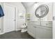 Bathroom featuring a gray vanity and a round mirror at 3233 Bagley Psge, Duluth, GA 30097