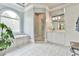 This spacious bathroom features a soaking tub, shower, and a large arched window at 3233 Bagley Psge, Duluth, GA 30097