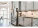 A modern kitchen features gray cabinets, stainless steel appliances, and a view to the breakfast nook with large windows at 3233 Bagley Psge, Duluth, GA 30097