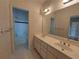 Bathroom with a dual sink vanity, classic wallpaper, and access to a tub at 1272 Saxony Se Dr, Conyers, GA 30013