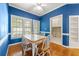Dining area with blue walls features a table with seating, a door, and a cabinet at 1272 Saxony Se Dr, Conyers, GA 30013