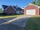 Brick home with driveway leading to a detached garage and a view of the backyard at 1272 Saxony Se Dr, Conyers, GA 30013