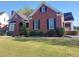 Beautiful brick home with dark shutters, a manicured lawn, and lush landscaping at 1272 Saxony Se Dr, Conyers, GA 30013