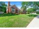 Charming brick home featuring a well-manicured lawn, mature trees, and classic architectural details at 1272 Saxony Se Dr, Conyers, GA 30013