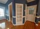 Well-lit hallway with hardwood floors, built-in shelving, and access to multiple rooms at 1272 Saxony Se Dr, Conyers, GA 30013