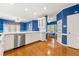 Open kitchen with stainless steel appliances, white cabinets and hardwood floors at 1272 Saxony Se Dr, Conyers, GA 30013