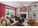 Cozy living room featuring a fireplace, built-in bookshelves, and a large window with natural light at 1272 Saxony Se Dr, Conyers, GA 30013