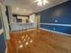 Open-concept living area with hardwood floors, blue walls and white kitchen in background at 1272 Saxony Se Dr, Conyers, GA 30013