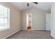 Bright bedroom features neutral walls, carpet, and ceiling fan with light, view of bathroom in doorway at 2386 Mills Bnd, Decatur, GA 30034